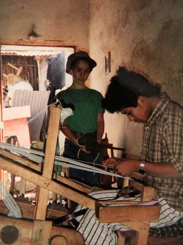 tissus pur coton au Guatemala, une petite fille regarde un artisan tisser avec un métier manuel