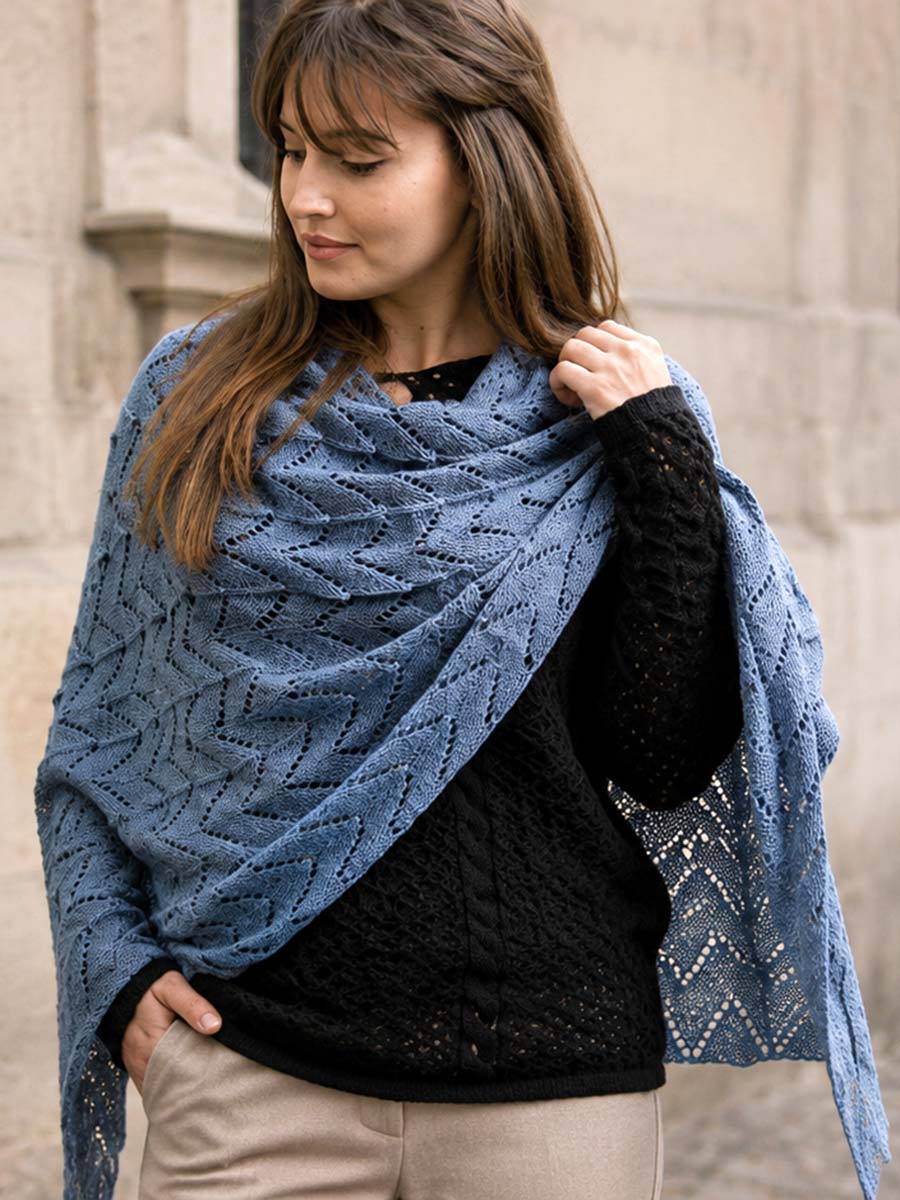 Femme portant un pull noir ajouré et un châle bleu en automne